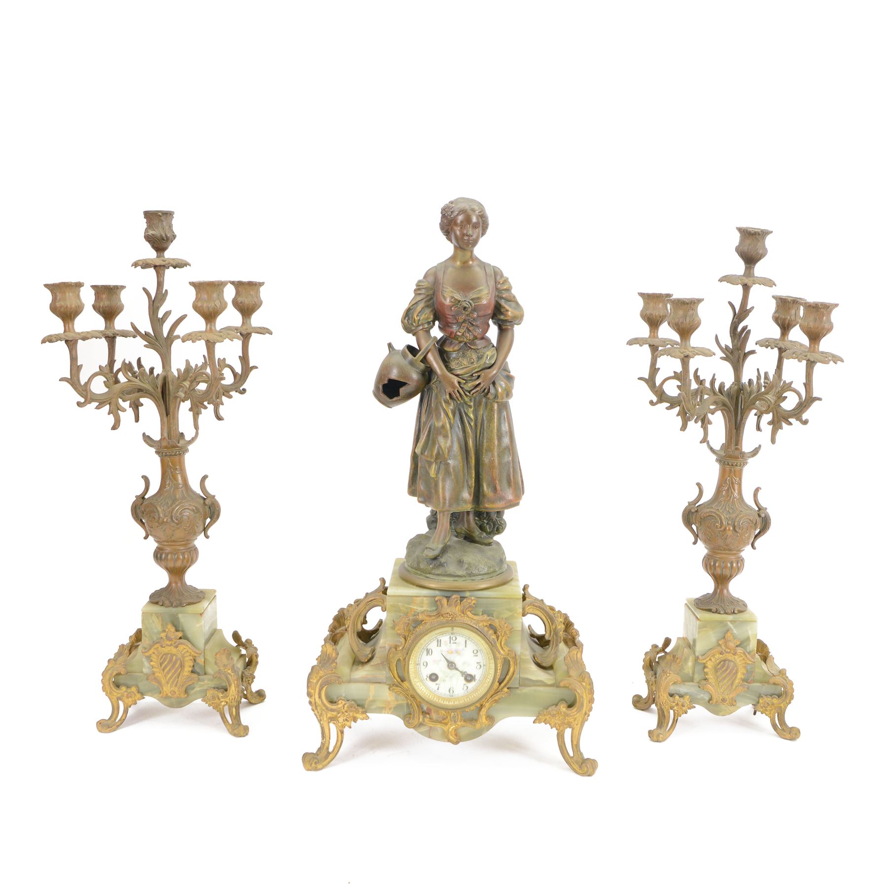 French-Edwardian green onyx clock garniture with a shaped case surmounted by a cast patinated figure of  a maiden in 18th century dress, with gilded scroll feet and conforming mounts, porcelain dial with Arabic numerals and floral decoration, twin train rack striking movement sounding the hours and half-hours on a bell, with a matching pair of five light candelabra. With pendulum.    