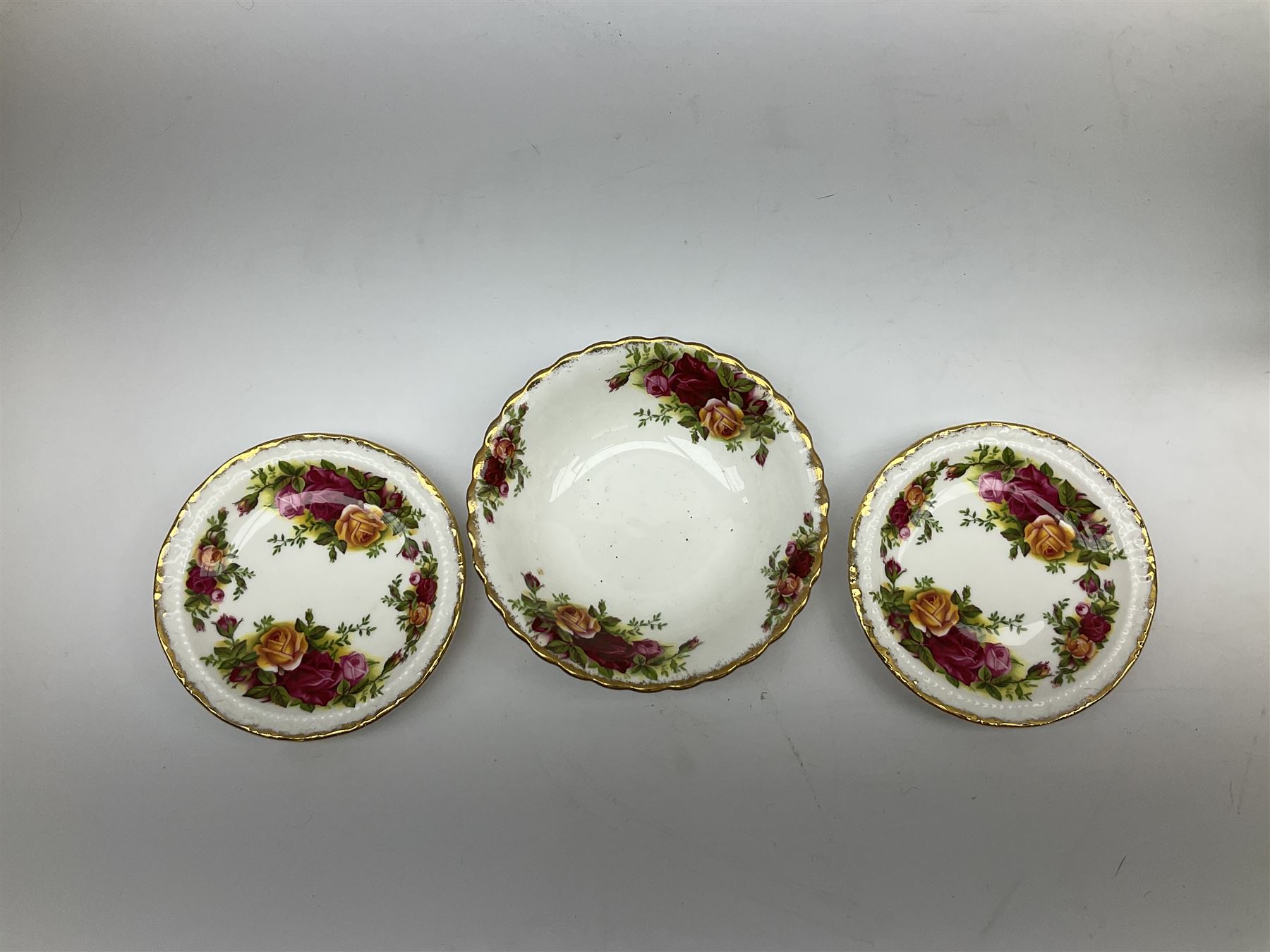 Royal Albert Old Country Roses part dinner and tea service comprising teapot, four tea cups and saucers, eight dessert plates, cake plate, cake stand, a tureen with cover, six dinner plates, an oval dish, two trinket dishes, bell and shoe decoration. 