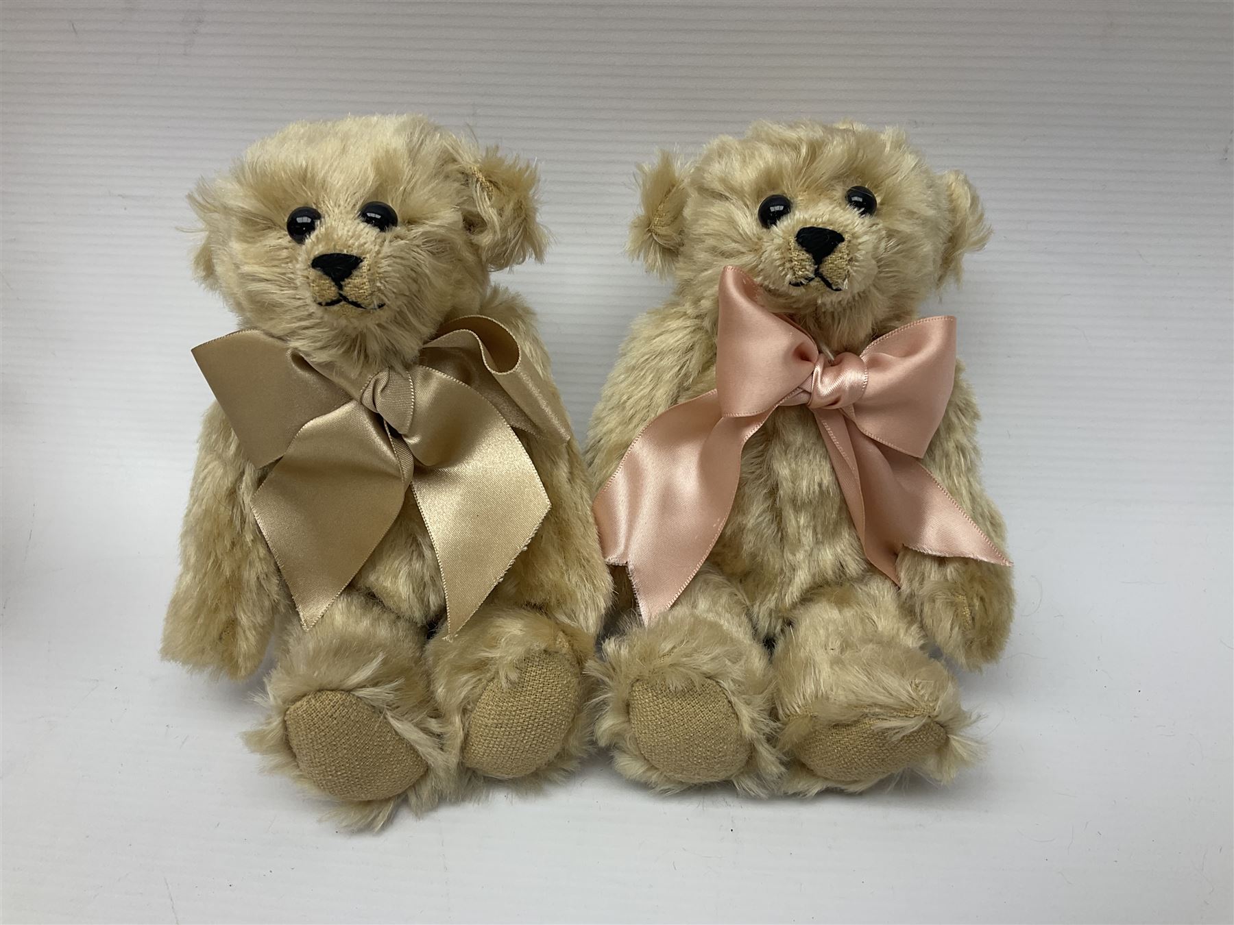 Group of five teddy bears comprising ‘George’ a unique pellet filled bear with glass eyes and velvet paws H38cm, and ‘Abbey’ a luxury German plush with wobble head and glass eyes no.5/10 H24cm, both with Teddies from Bearyland labels; along with two light blonde mohair H. M. Bears and Boyds Bears ‘T. F. Wuzzies’ no. 595140 (5)