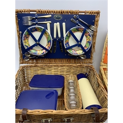  Two wicker picnic baskets, the largest by Optima and fitted for four people, the smaller unmarked and fitted for two, largest when closed H20cm L56 D38.  