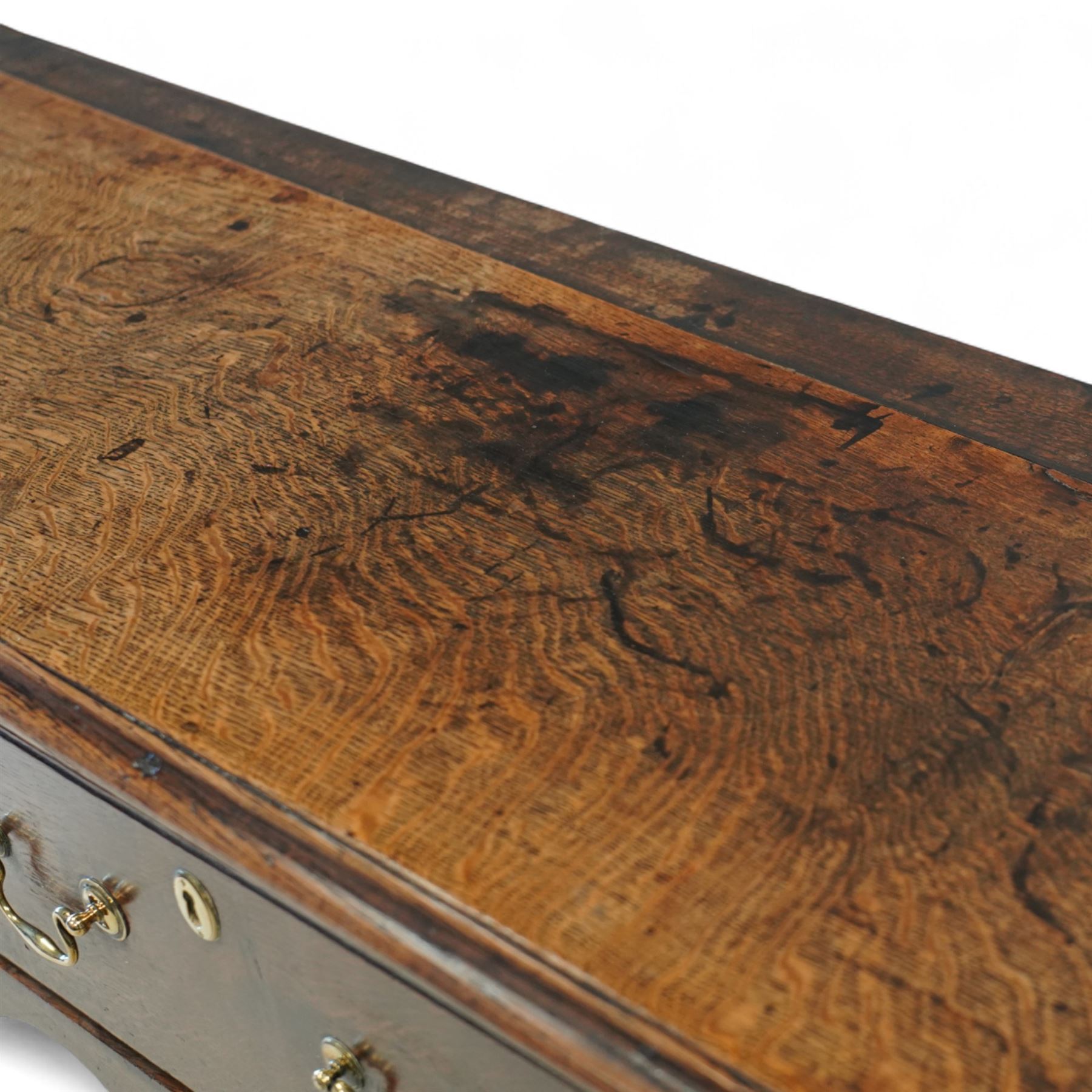 George III oak dresser base, fitted with three drawers with brass swan-neck handles, shaped apron and cabriole legs on pad feet 