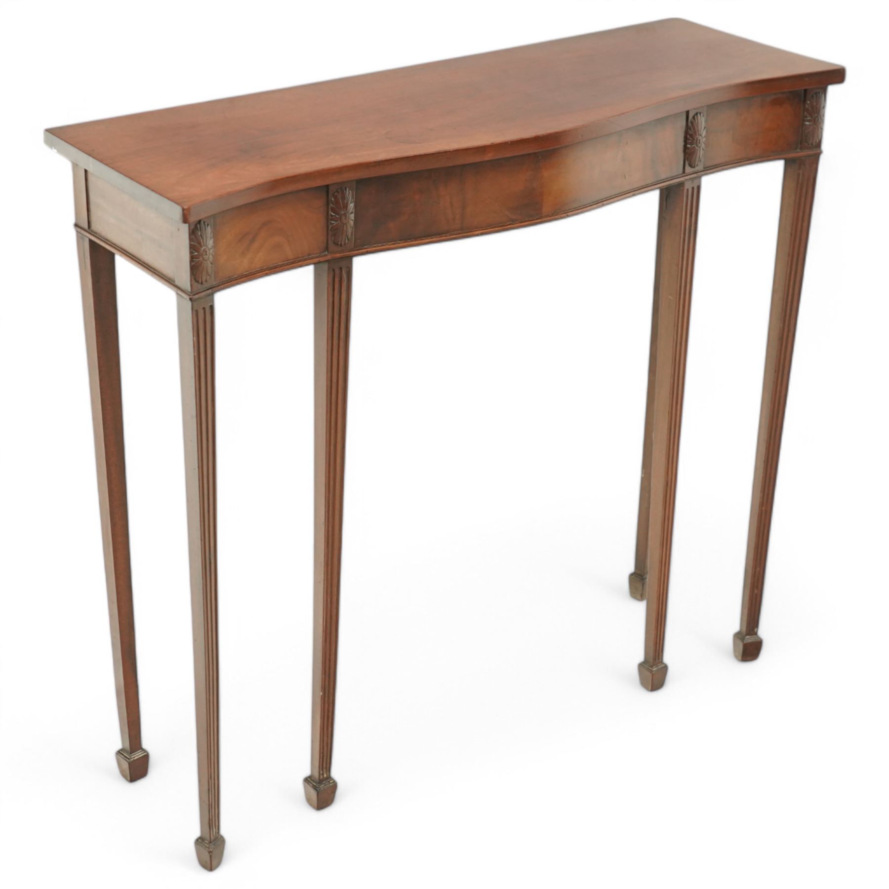 Edwardian mahogany serpentine side table or console table, figured frieze decorated with applied carvings, on six square tapering supports with spade feet