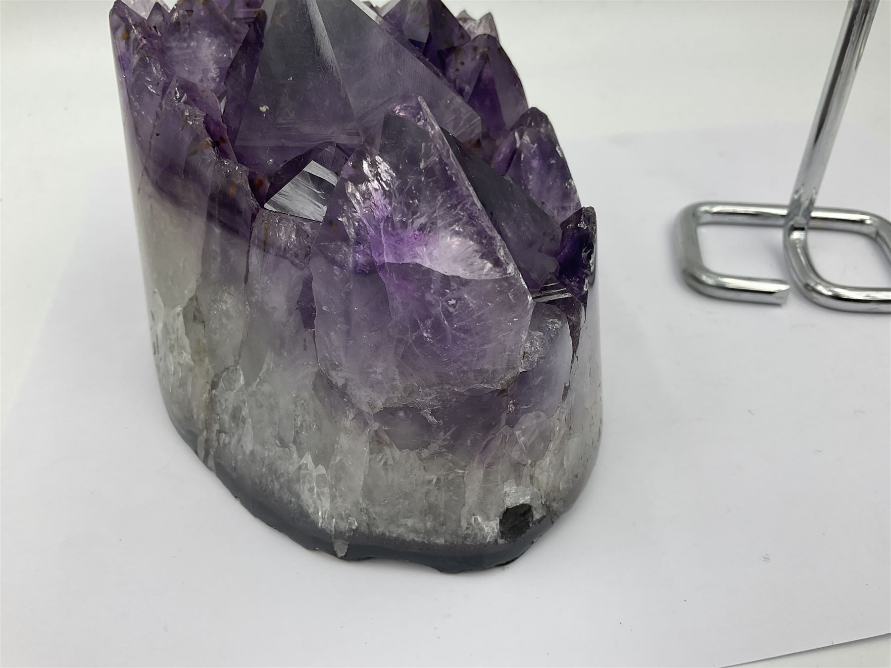 Amethyst crystal geode cluster, with large well-defined crystals, upon a metal stand, H21cm