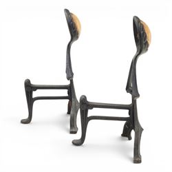 Arts and Crafts cast iron and brass andirons, brass and copper acorn finials above openwork uprights, raised on shaped arched feet with hammered detail
