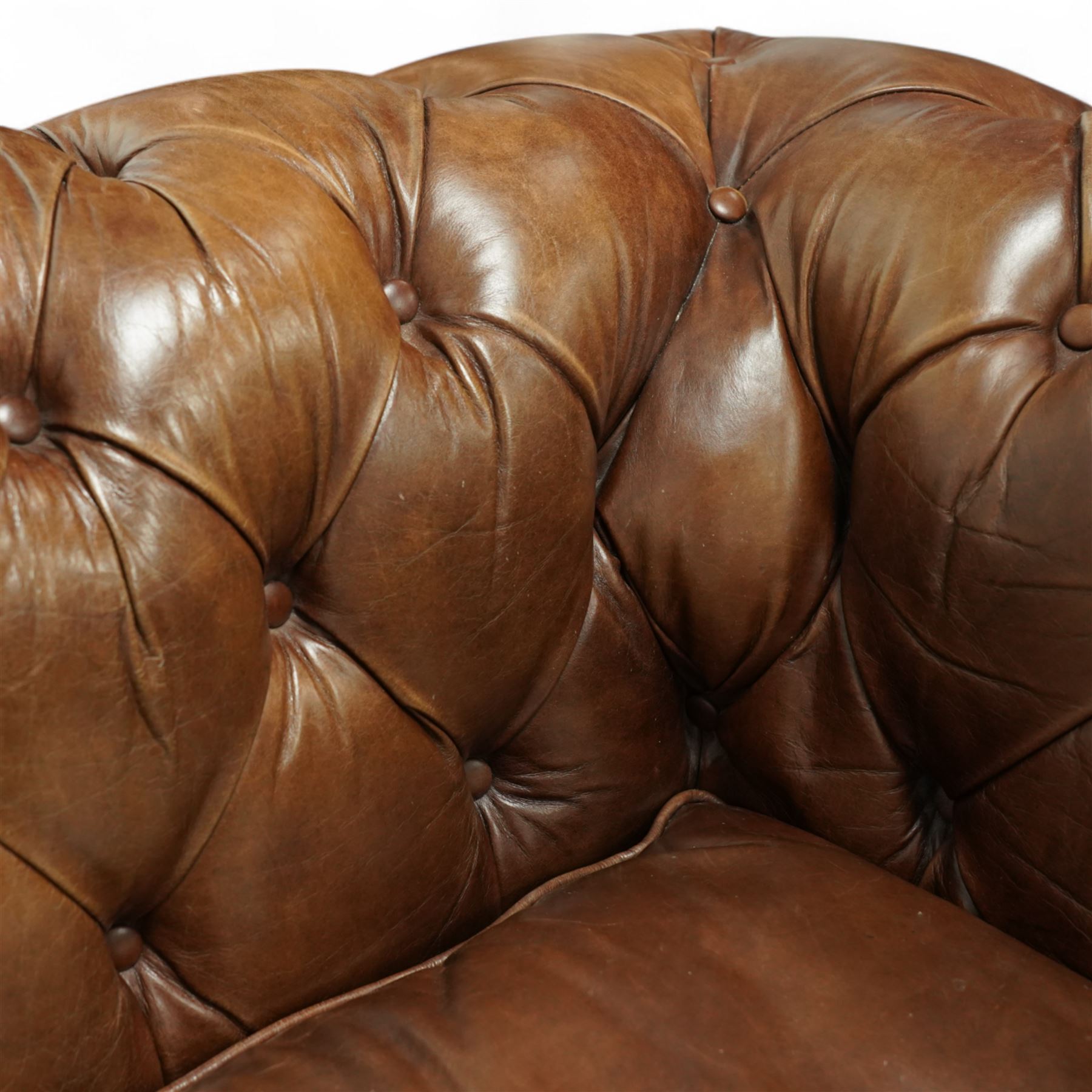 Timothy Oulton, Halo - late 20th century brown leather Chesterfield settee, the upholstered frame with deep buttoning to back and arms, large scroll terminals with brass studwork, twin seat cushions, raised on castored legs