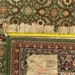 Central Persian Kashan rug, emerald green ground, with a central ivory, indigo, and brick red lobbed medallion with pendant finials, ivory spandrels, framed by multiple floral borders