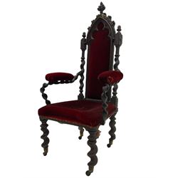 Victorian oak and wrought metal Gothic open armchair, the pointed arched back carved with foliate, cusped inner arch upholstered in red, spiral turned uprights and supports, with arms made of spiral forged metal