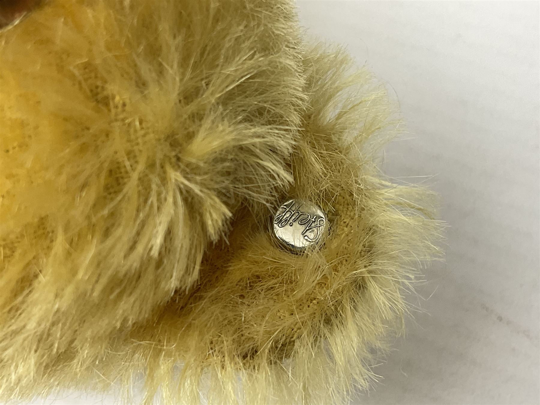 Steiff teddy bear with golden plush body, revolving head, applied eyes, vertically stitched nose and mouth and jointed limbs; button to left ear H26cm; and two other Steiff teddy bears, each with open mouth and button with tag to left ear (3)
