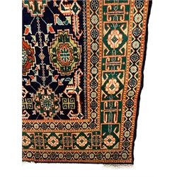 Small Persian indigo ground rug, the field decorated with Gilt motifs with trailing bead and stylised foliage, emerald green ground border decorated with geometric design and flower heads