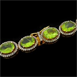 Silver-gilt peridot and diamond necklace, thirty-eight clusters, each set with a single oval cut peridot and round brilliant cut diamond surround, total peridot weight approx 57.00 carat, total diamond weight approx 5.00 carat