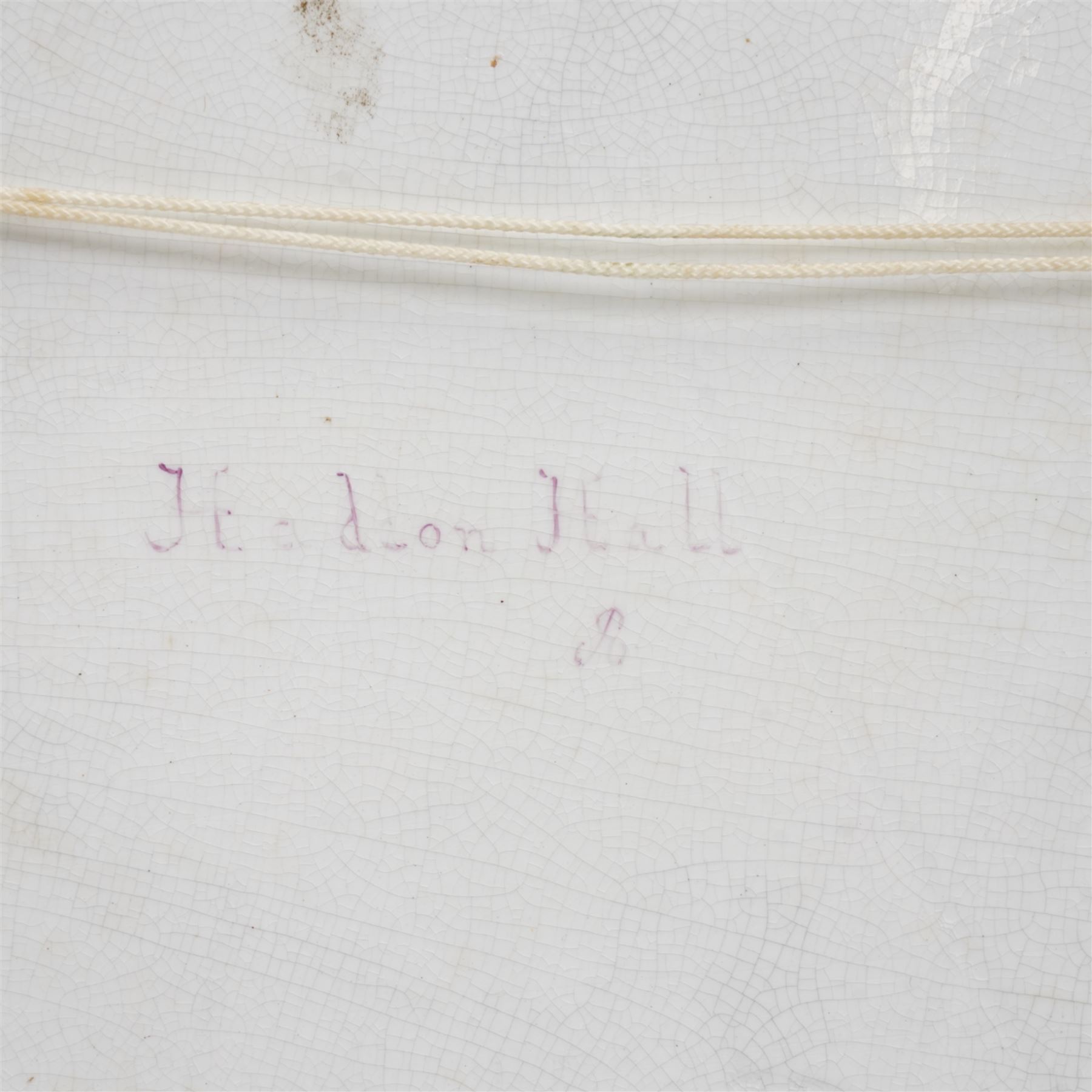 English porcelain plaque depicting Haddon Hall, with painted title and 'R' signature verso, overall 25.5cm x 35cm 