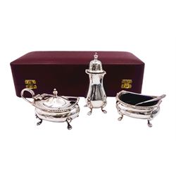 Modern silver three piece cruet set, comprising pepper, mustard pot and cover with blue glass liner, open salt with blue glass liner, and salt spoon, each with oblique gadrooned rim, hallmarked William Suckling Ltd, Birmingham 1961 and 967, contained within a fitted case with burgundy velvet and cream silk lined interior, approximate total silver weight 7.09 ozt (220.5 grams)