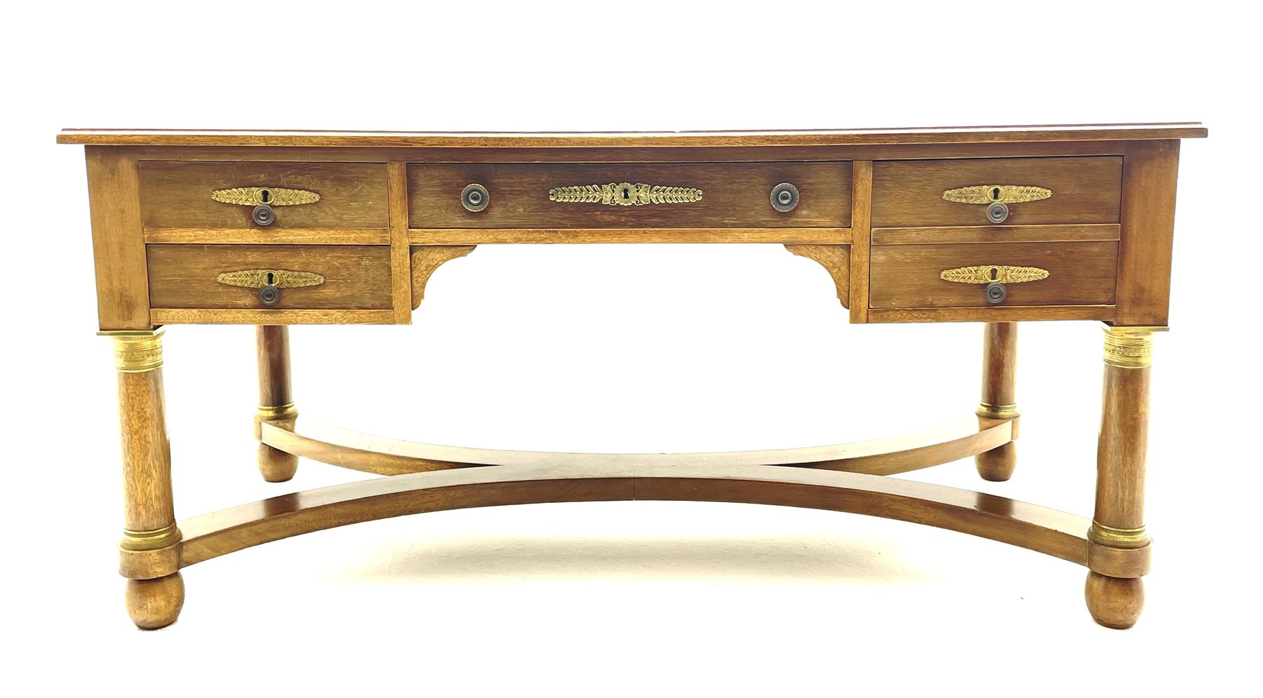 French Empire style walnut desk, moulded rectangular top with inset leather, two leather inset slides either side, fitted with four drawers, turned supports joined by curved x-shaped stretchers, gilt metal mounts 