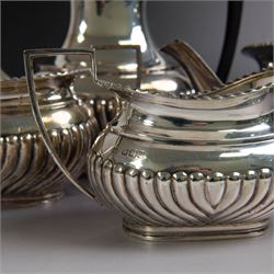 Edwardian silver four piece tea service, comprising coffee pot, teapot, twin handled open sucrier and milk jug, all of oval bellied form, part fluted and with oblique gadrooned rim, with Bakelite type handles and finials to teapot and coffee pot, hallmarked Fordham & Faulkner, Sheffield 1913