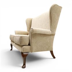 Parker Knoll - 'Hartley' lounge suite, comprising three wingback armchairs and two-seat settee, upholstered in cream fabric, shaped wing backs with scroll-over arms and loose seat cushions, on cabriole supports with pad feet wingbacks and settee

Armchairs: H 96cm, D 83cm, W 75cm