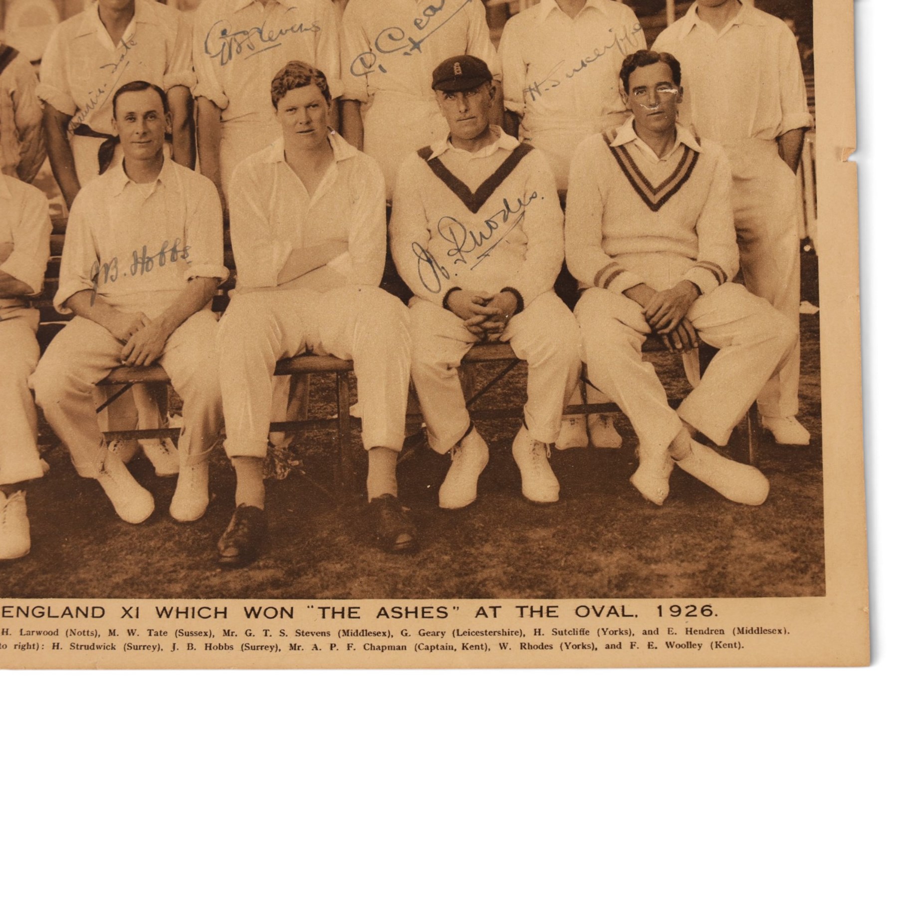 1920s All Sports Illustrated magazine page, depicting the 1926 Ashes winning England cricket team, signed by seven players including Maurice Tate, Greville Stevens, George Geary, Herbert Sutcliffe, Herbert Strudwick, Jack Hobbs and Wilfred Rhodes, mounted on card