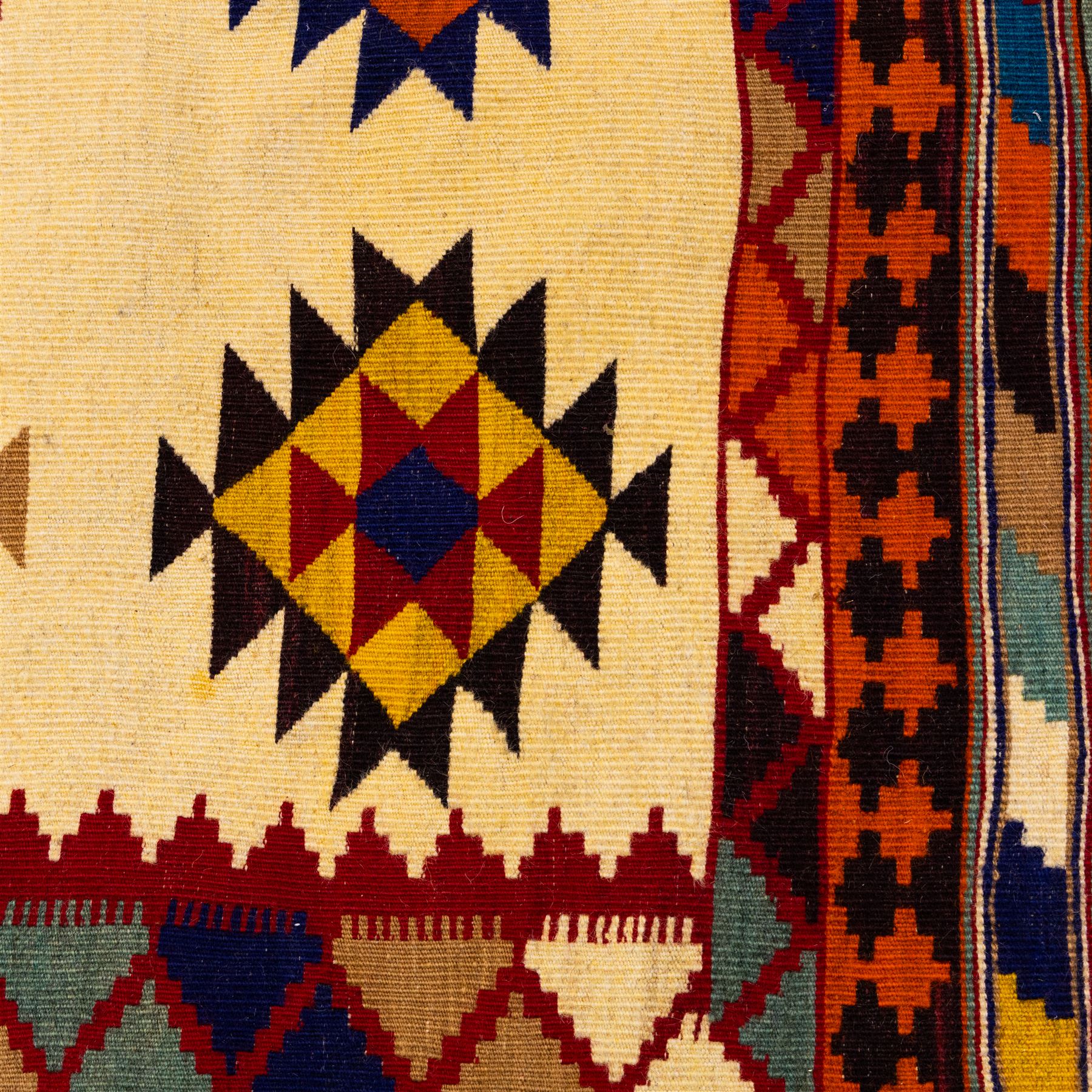 South West Persian Qashqai flatweave kilim, ivory field decorated with rows of multicoloured stepped diamond medallions composed of angular geometric motifs, enclosed by bold polychrome borders of triangular devices and stylized geometric, ornamentation, with fringe ends 