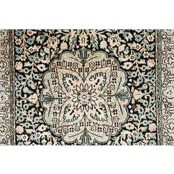 Persian style rug, central floral medallion surrounded by intricate palmetters, vines and rosettes, navy blue ground with ivory and pink highlights