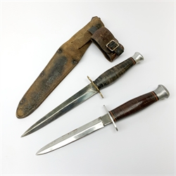 American WW2 type fighting knife with 14cm steel double edged blade, brass crosspiece, leather bound grip and aluminium pommel, in leather sheath marked twice 10C/A L27cm overall; and another similar fighting knife without sheath (2)