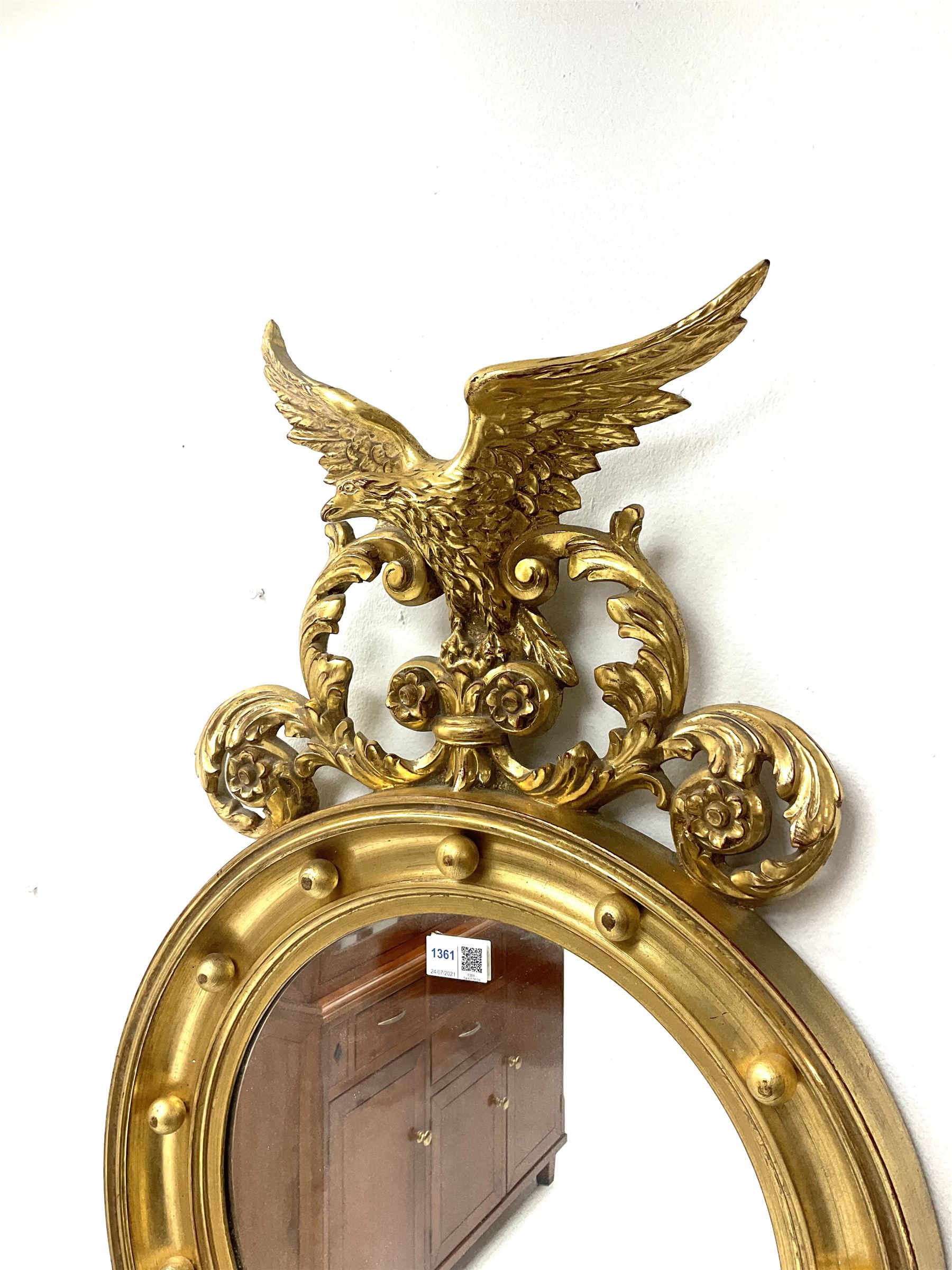 Reproduction Regency style gilt wall mirror, the eagle and leaf scroll pediment over circular mirror plate
