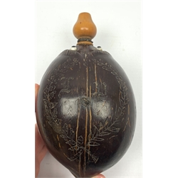 Napoleonic coconut bug bear flask with carved decoration and initials, inset glass eyes and turned boxwood pear shaped nozzle L17cm