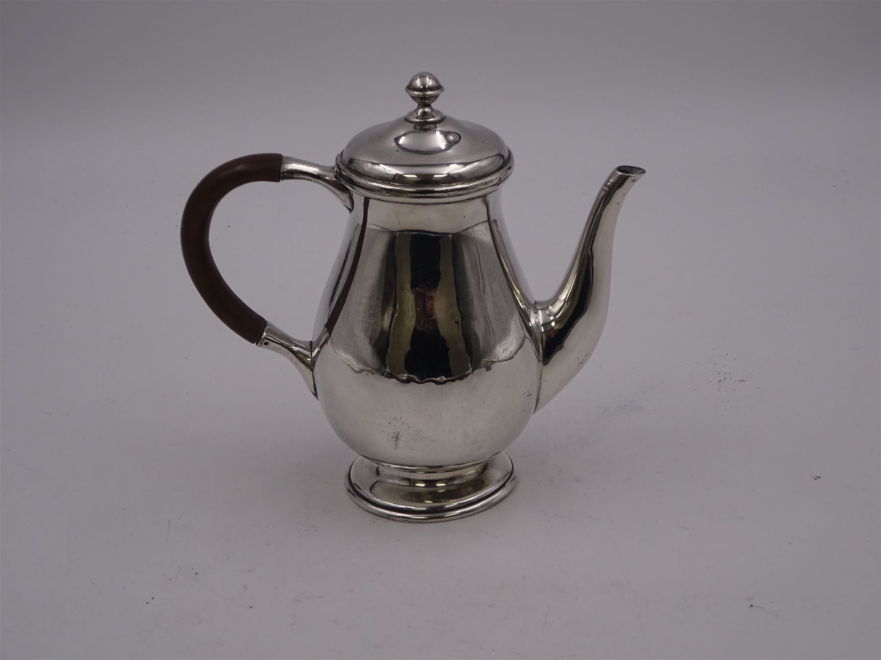 Liberty & Co 1930s small silver coffee pot, of plain baluster form, with brown Bakelite C handle with trefid mounts and cover with spherical knopped finial, upon circular stepped foot, hallmarked Liberty & Co, Birmingham 1934