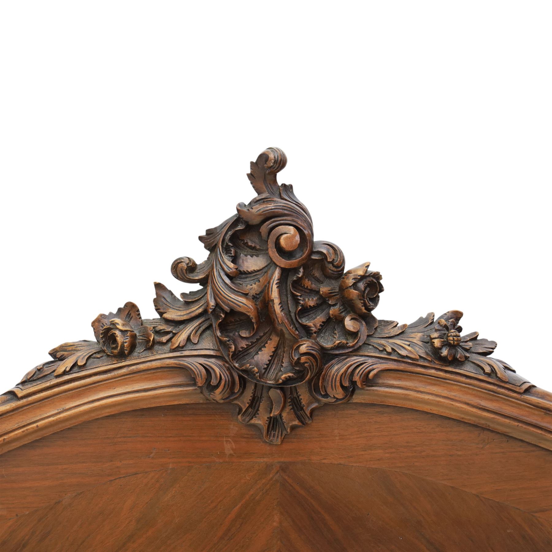 Early 20th century French walnut single bedstead, the shaped and moulded headboard with carved foliate crest above a panelled field, with conforming serpentine footboard with moulded reserves, the shaped apron with applied carved detail, raised upon cabriole supports with carved knees