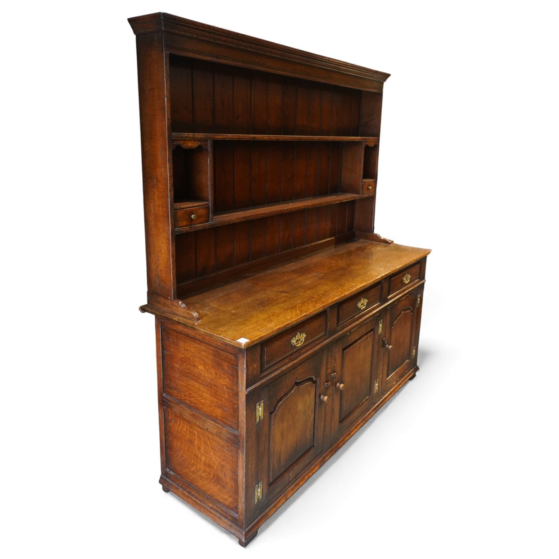17th century style oak dresser, in the manner of Titchmarsh & Goodwin, fitted with a moulded top over three drawers and cupboard doors, the superstructure formed as a two tier panelled plate rack with integral trinket drawers