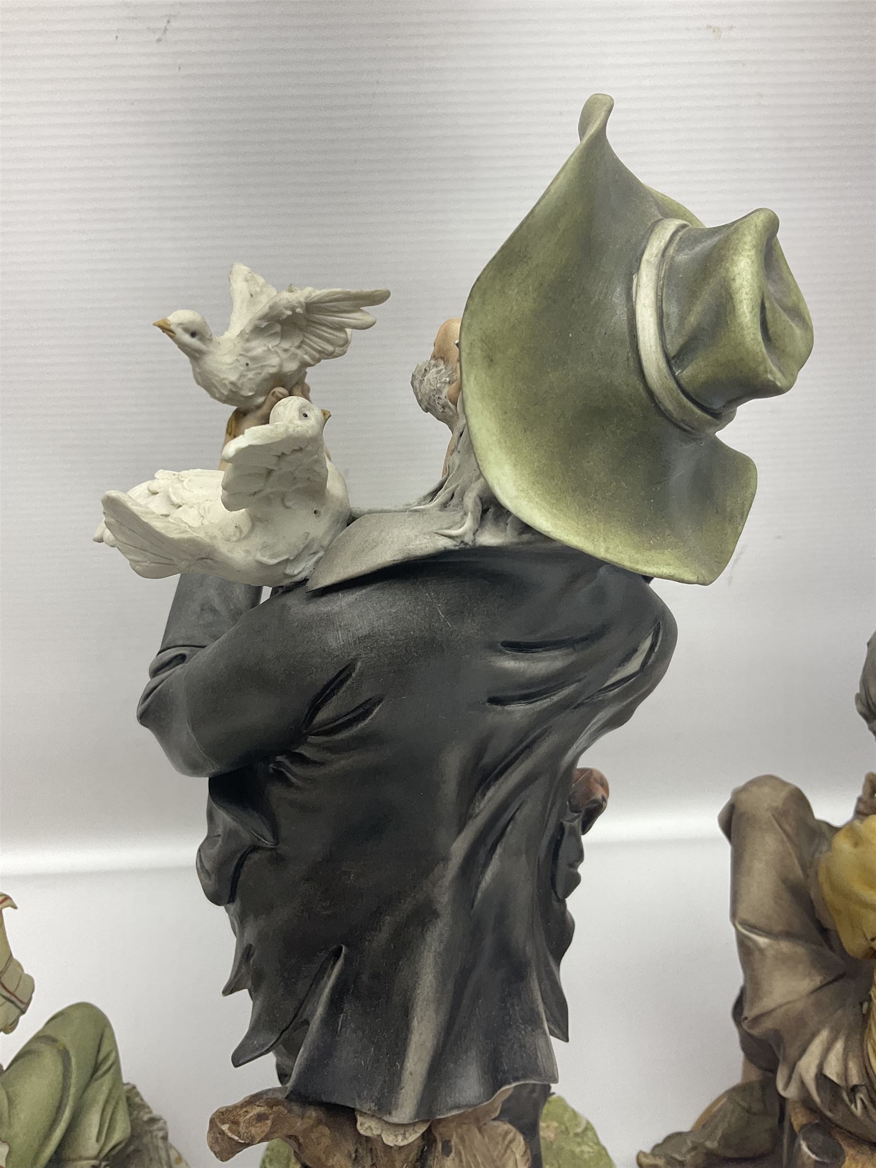 Three Capodimonte figures, to include The Kind Heart Man, modelled by Cortese as a tramp with two doves, The Young Falconer by Maria Angela and another modelled as a tramp darning his socks, all with printed marks, tallest H39cm