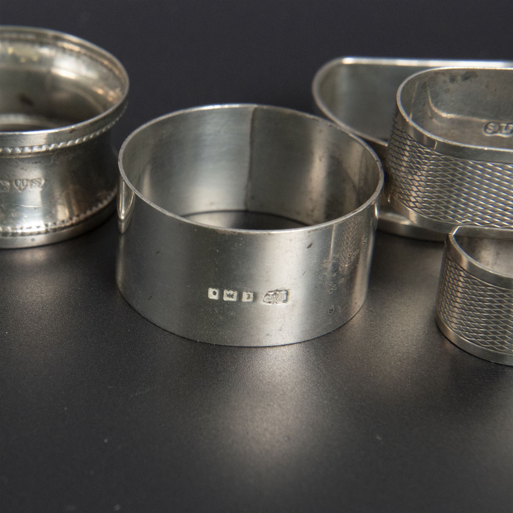 Five silver napkin rings, including pair of 1930s oval examples, with engine turned decoration with engraved initial, together with a collection of silver flatware, including Norwegian spoon, pair of Fiddle pattern mustard spoons, five seal top coffee spoons, etc, all stamped or hallmarked