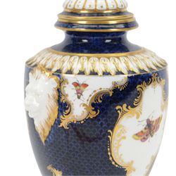 Late 19th century Royal Worcester porcelain vase and cover, circa 1897, of baluster form with twin lion masks to shoulders, painted with a reserve of exotic birds within a landscape, against a blue scale ground with gilt highlights, and further detailed with smaller reserves containing butterflies, the shoulder, base of body and foot with moulded acanthus bands, upon a circular spreading foot, with green printed marks beneath including shape number 2305 and Rd no 419210, H27.5cm