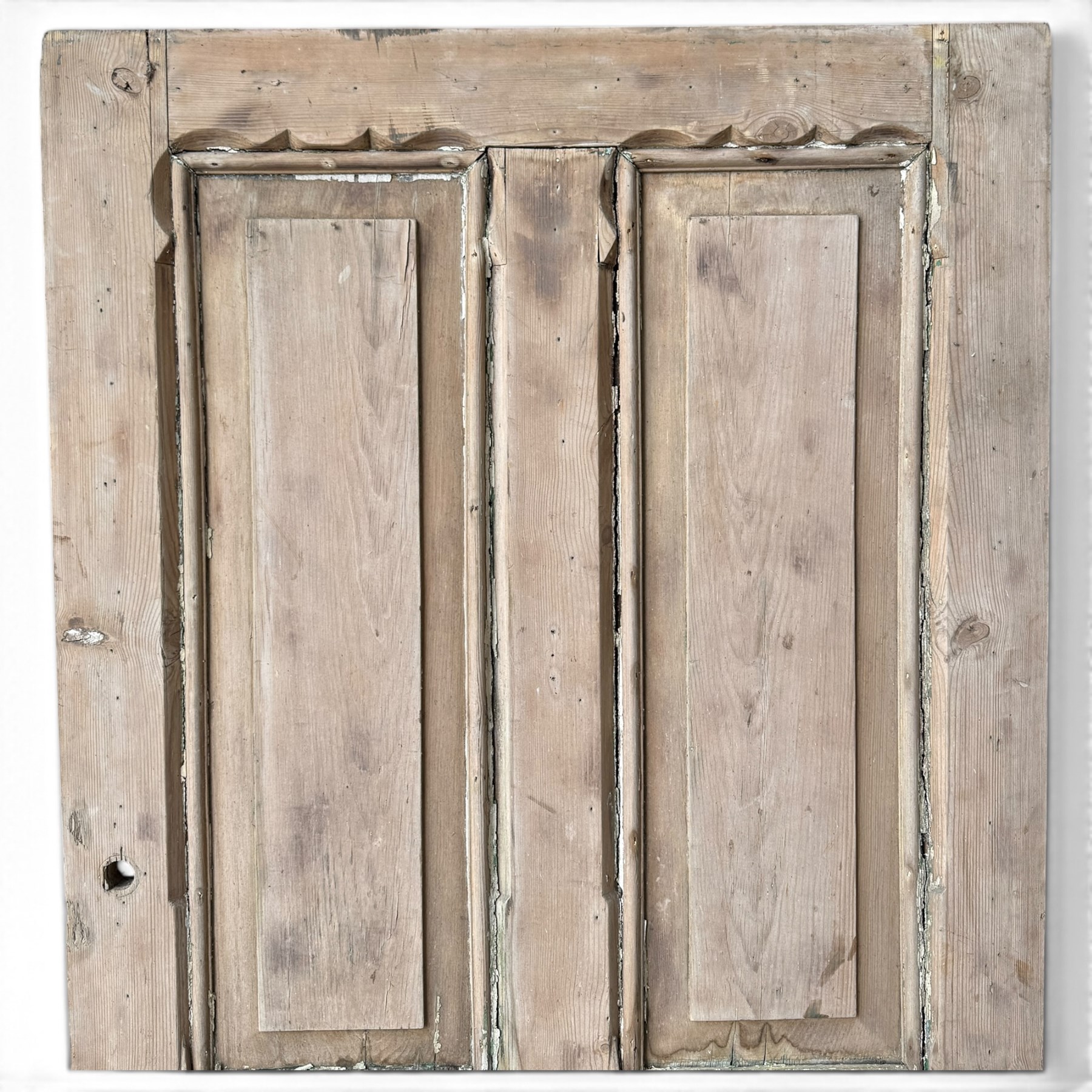 Victorian stripped pine four-panel door, the raised fielded panels within carved foliate and moulded surrounds, with iron lock and fittings and brass knob handle