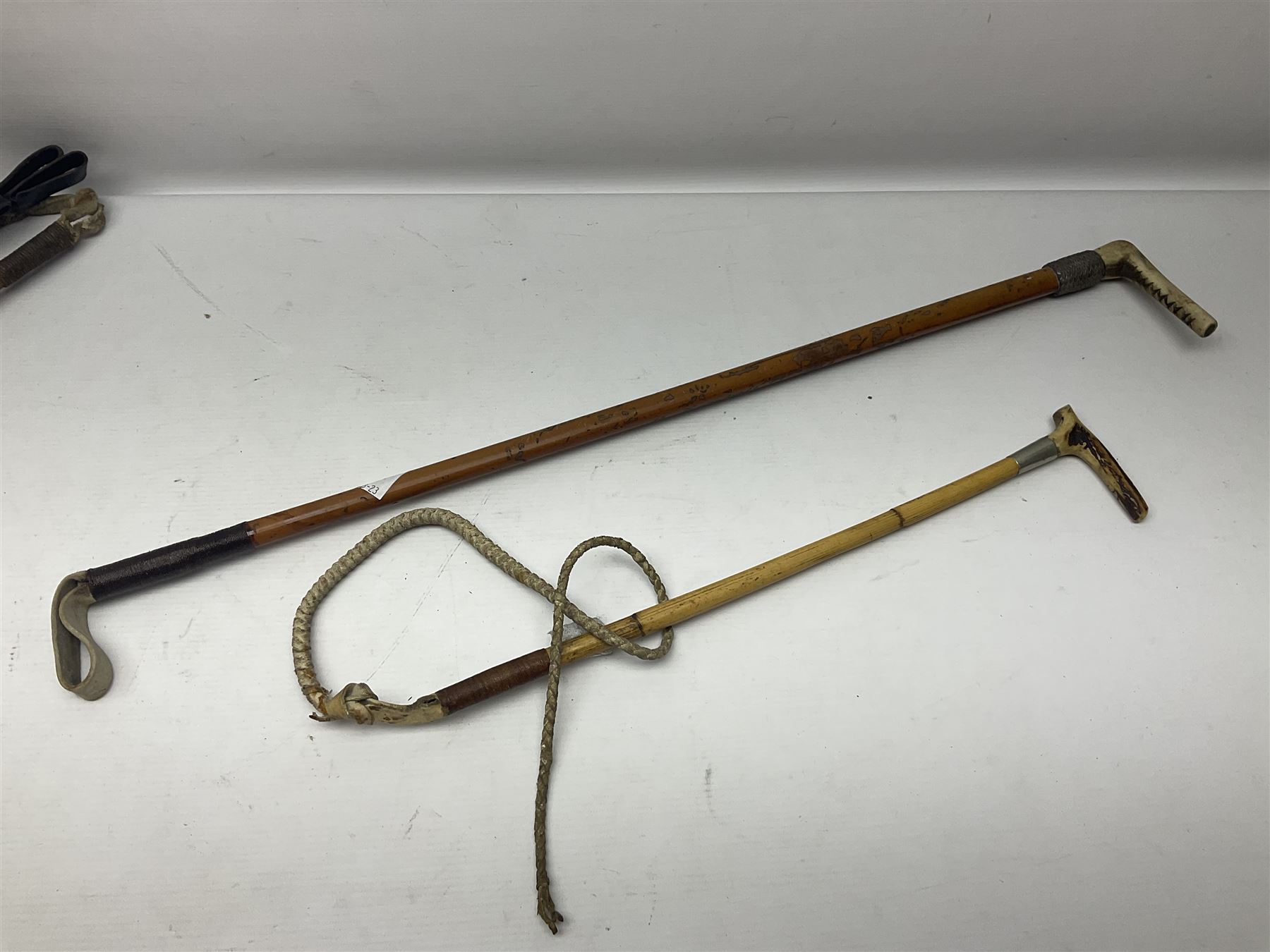 Collection of hunting crops and riding whips, including horn handle examples with silver cuffs