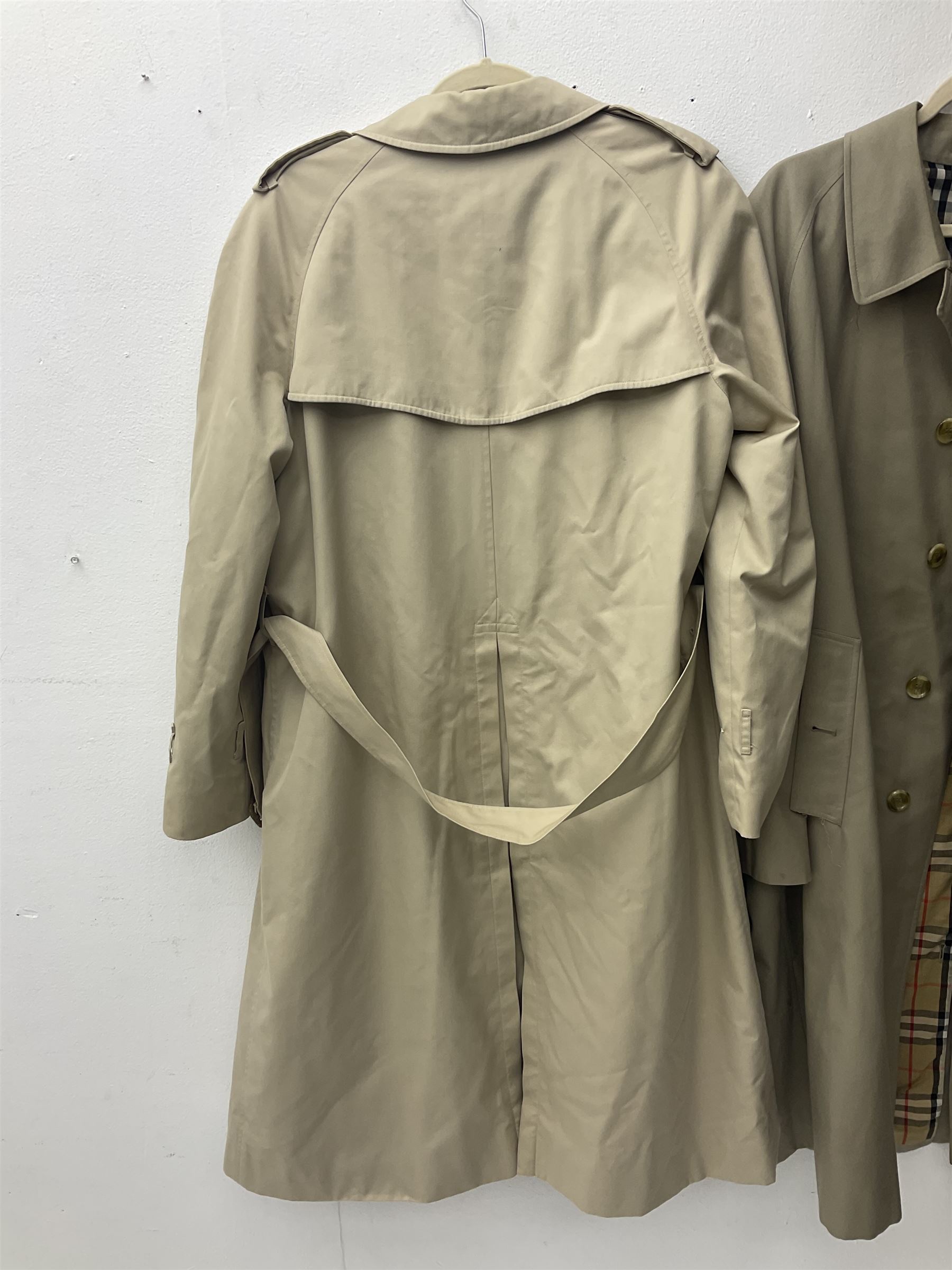 Ladies Burberry double breasted trench coat, with belt and detachable woollen gilet, in traditional cream colour with Burberry check lining, together with a gentlemans Burberry single breasted trench coat, both L112cm