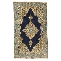 Central Persian Qum indigo ground rug with silk inlay, the plain field decorated with floral design medallion and lattice spandrels, the wide border decorated with trailing flowers and foliage 