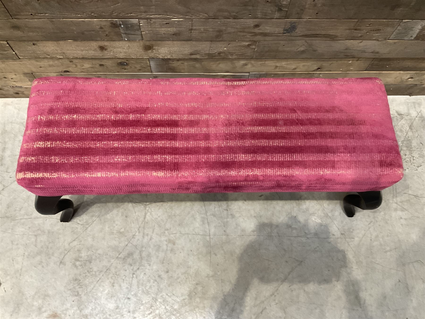 Large rectangular footstool upholstered in a maroon fabric with cabriole supports