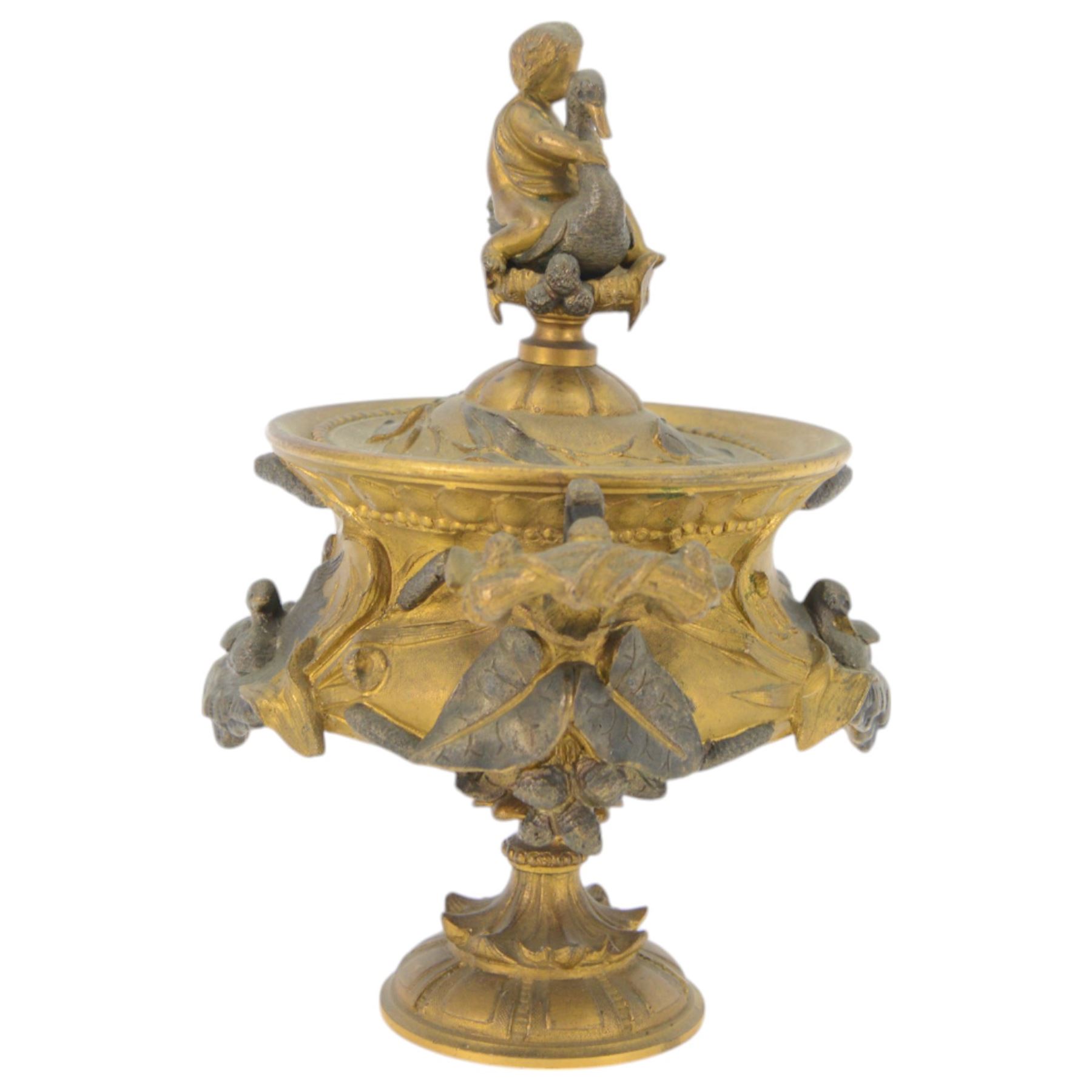 19th century gilt bronze twin handled urn, the removable cover with foliate decoration and finial modelled with a putti and swan, the body decorated in relief with swans and reeds, upon a circular foot, H19cm