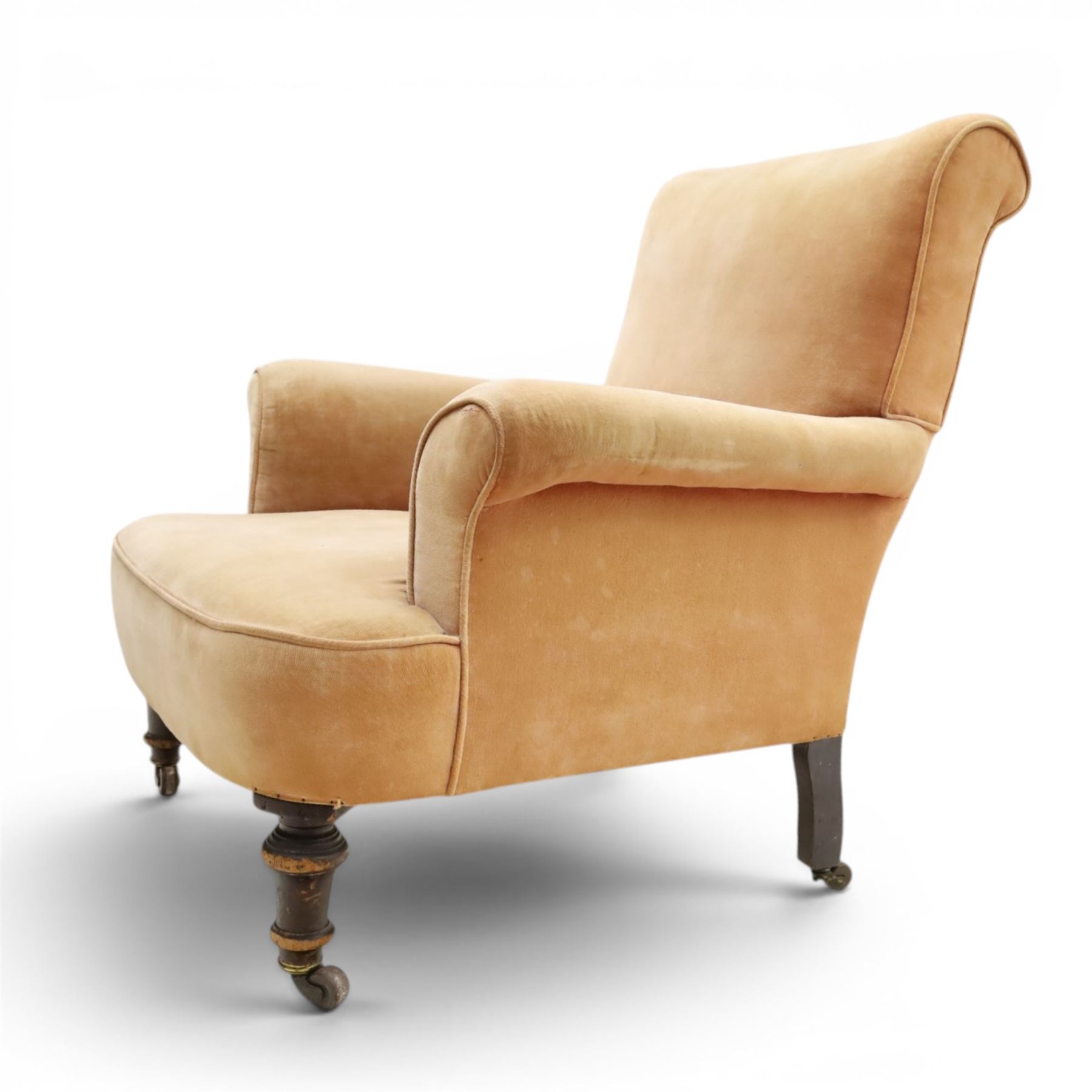 Victorian mahogany framed armchair of traditional shape, the high sprung rolled back over out-swept arms, deep sprung seat over turned feet with ceramic castors, upholstered in pale salmon pink fabric