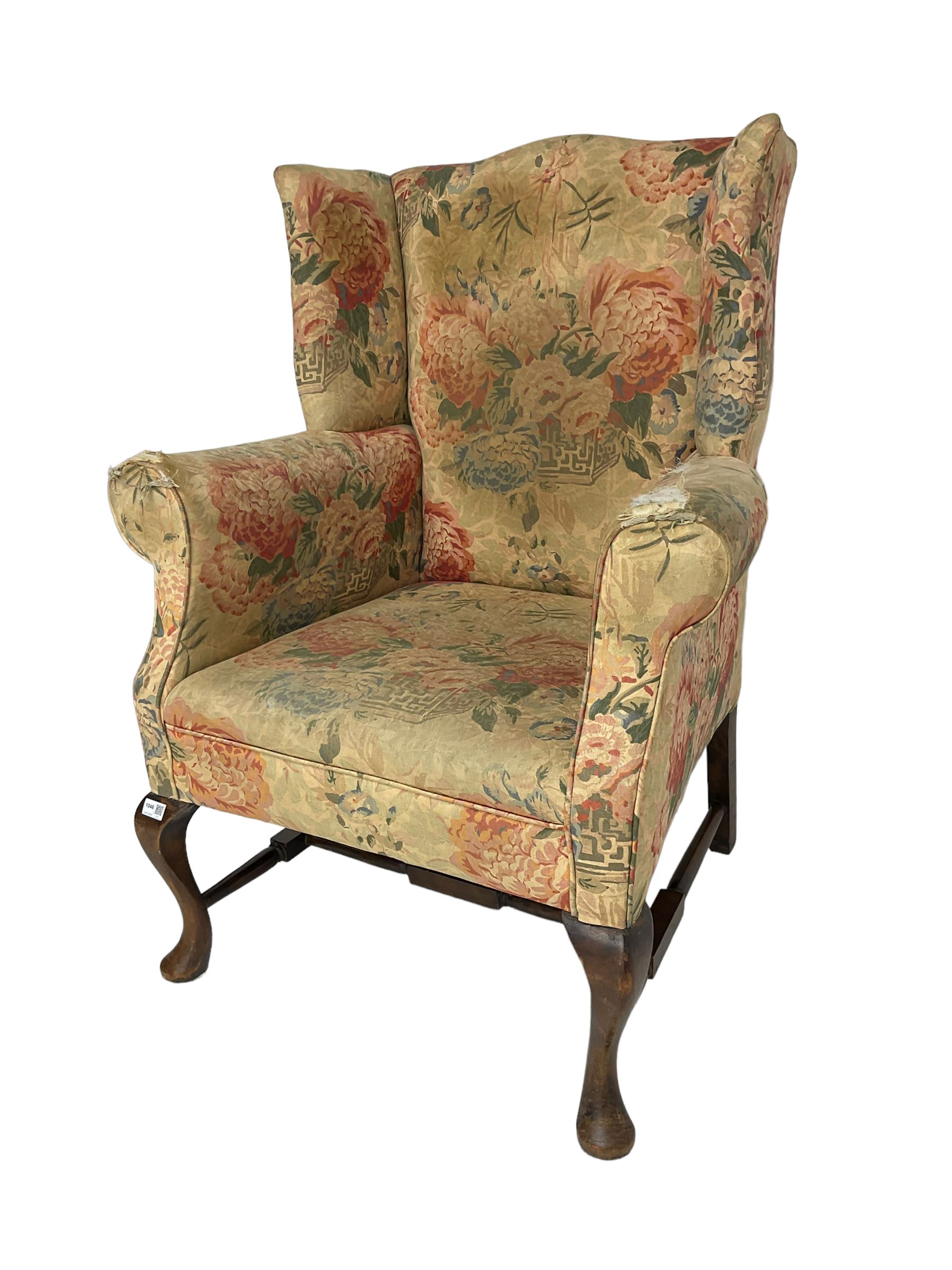 Early 20th century Georgian style wingback armchair, upholstered in floral fabric with sprung seat, walnut frame with front cabriole supports