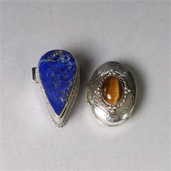 Two modern silver pill boxes, the first example of oval form, the hinged cover set with a tigers eye cabochon with beaded mount, and engraved scroll edge, hallmarked NC, London import 1995, W3cm, the second of teardrop form, the hinged cover set with lapis lazuli, marked 925, L3.5cm