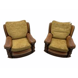 Pair of 1930’s carved oak framed club chairs, upholstered in tan studded leather with beige fabric loose cushions