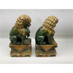 Pair of Chinese Temple Lions or Dogs of Foo, modelled in seated post, one with one front paw resting upon a ball, the other upon a cub, each upon stylised plinth base, H44cm