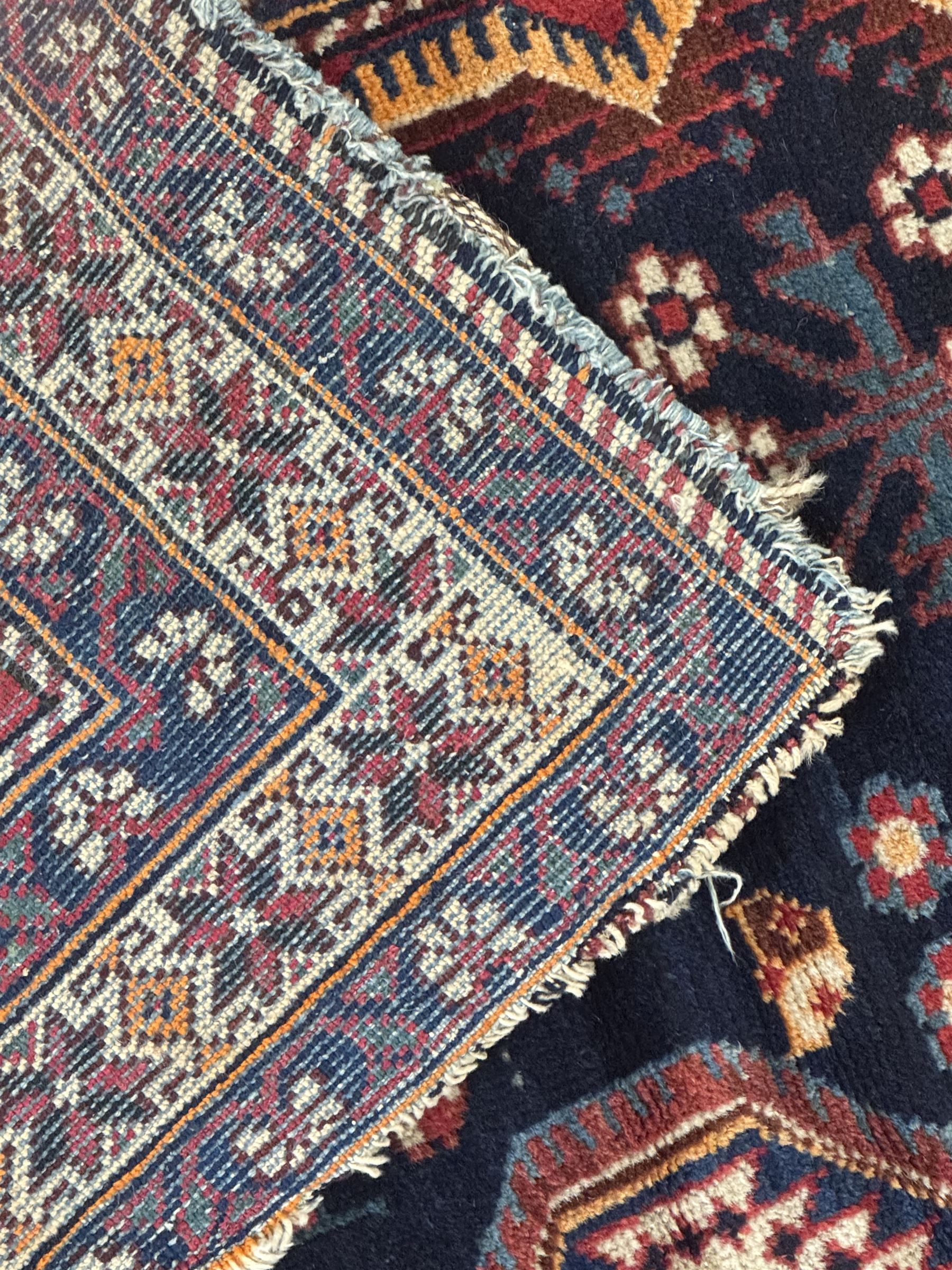 Persian Heriz wool rug, red and ivory field with floral medallion, geometric spandrels, and floral border (157cm x 107cm); Kurdish Shairwan wool rug, red and navy field with three medallions, geometric crosses and serrated border (200cm x 155cm); Persian Qashqai wool rug, golden-yellow field with boteh motifs and wide floral border (127cm x 82cm)