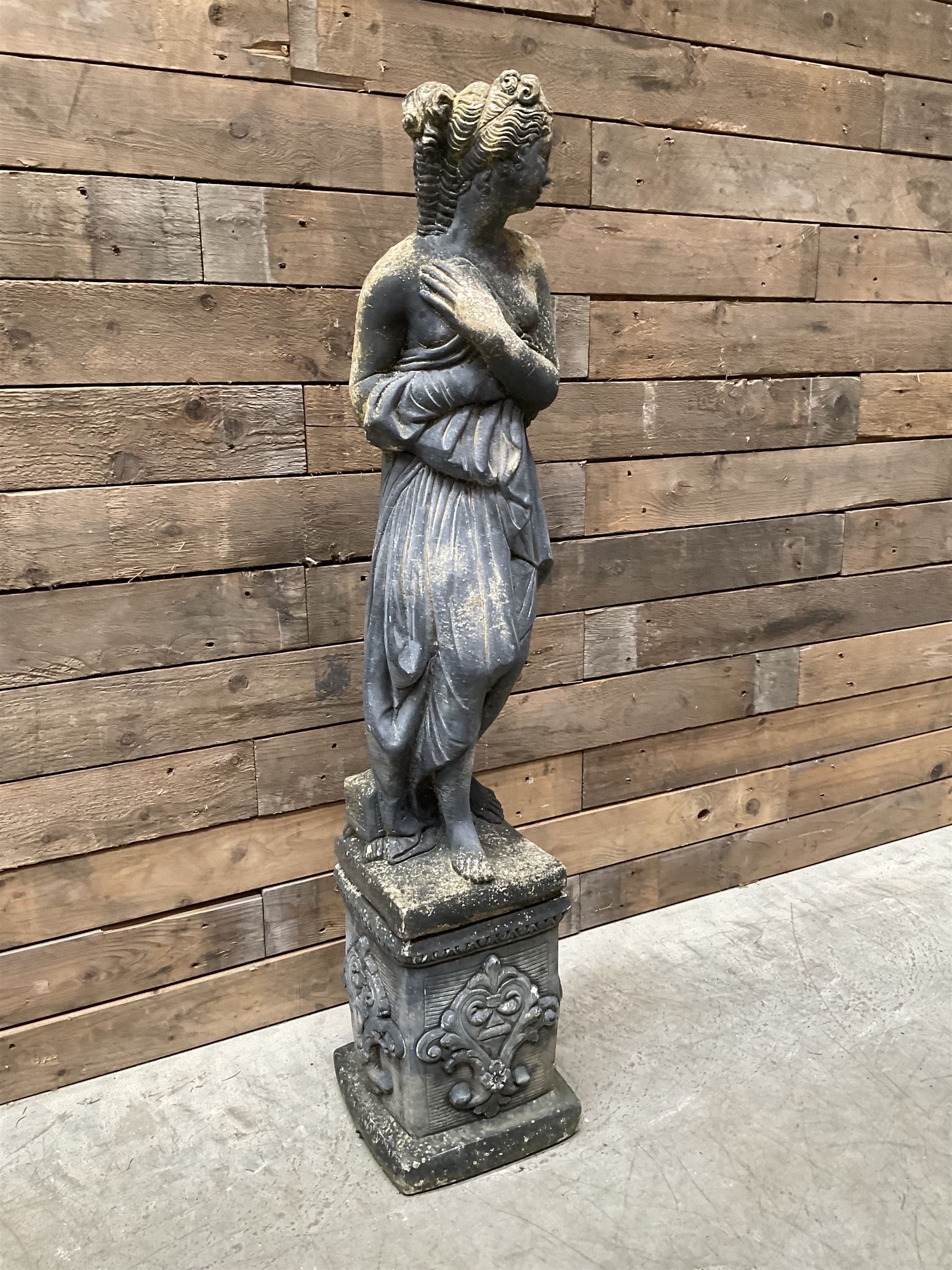 Cast stone weathered garden statue of Venus on pedestal