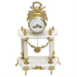 French-Early 20th century 8-day white marble and gilt metal striking portico mantle clock and garniture, Parisian drum movement with a white enamel dial, Arabic numerals and garland swags, two train countwheel striking movement sounding the hours and half hours on a bell. With a matching pair of conforming urns with gilt mounts. 
