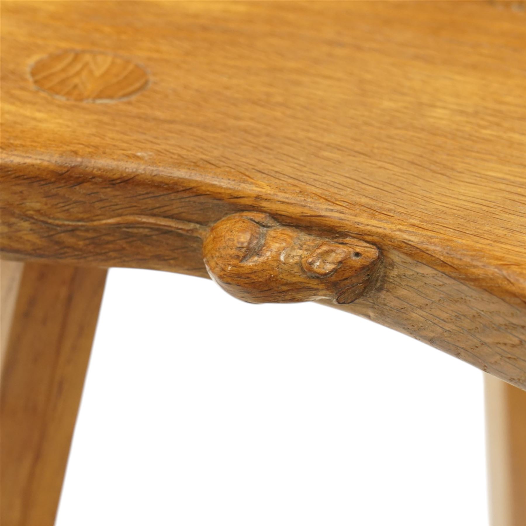 Mouseman - oak three-legged milking stool, dished kidney-shaped seat, raised on three octagonal splayed supports, with carved mouse signature, by the workshop of Robert Thompson of Kilburn