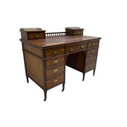 Maple & Co - Edwardian mahogany twin pedestal desk, the raised back with spindle gallery and open shelf to centre flanked by two trinket drawers, rectangular top with inset writing surface, fitted with one long and eight short graduating drawers flanked by fluted uprights, raised on brass and ceramic castors, stamped to central drawer