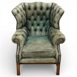 Georgian design mahogany framed wingback armchair, upholstered in rustic pale green button...