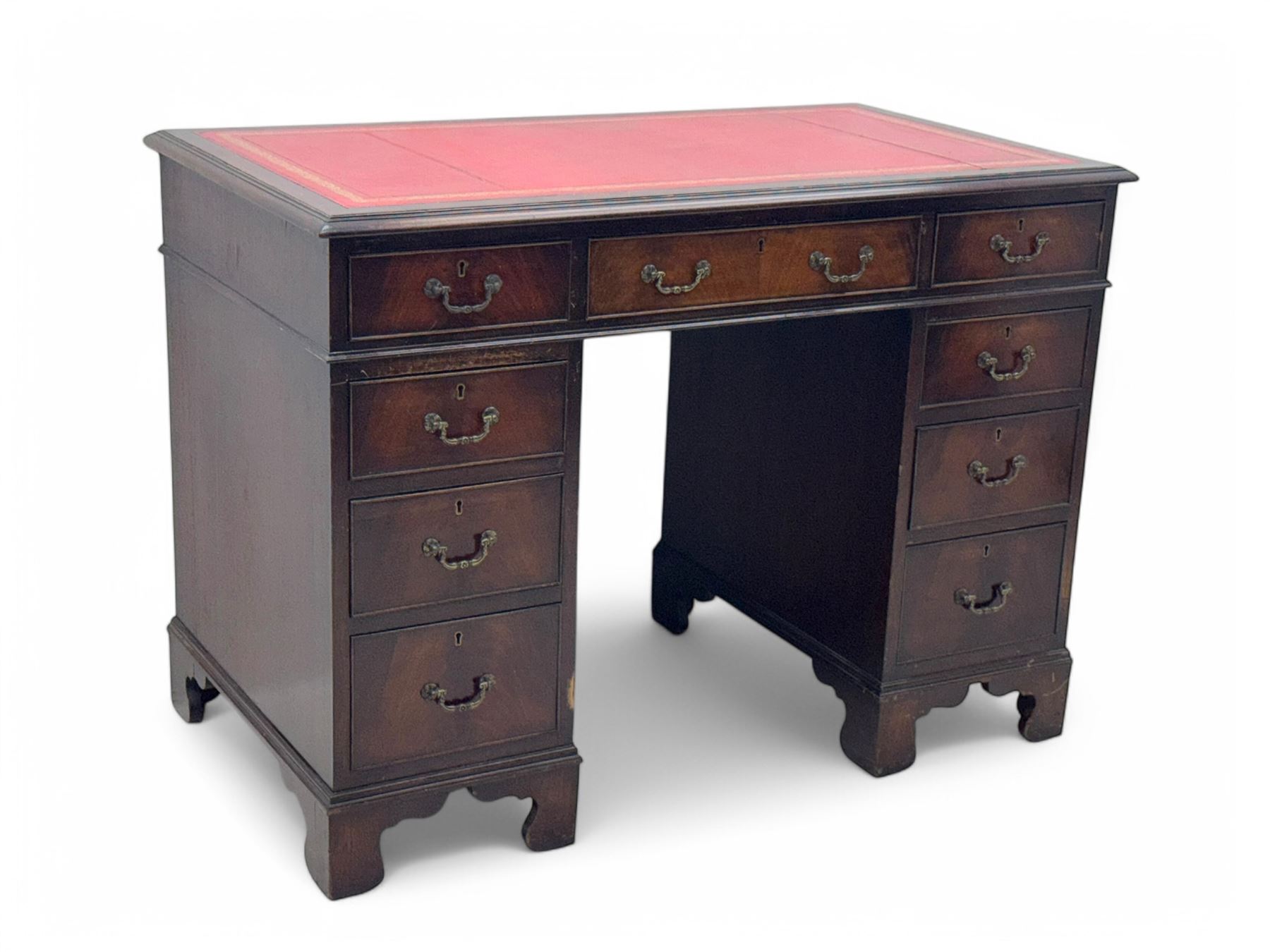 Georgian design mahogany kneehole desk, moulded rectangular top with red gilt-tooled leather writing surface, over an arrangement of nine cock-beaded drawers with brass swan neck handles, on bracket feet