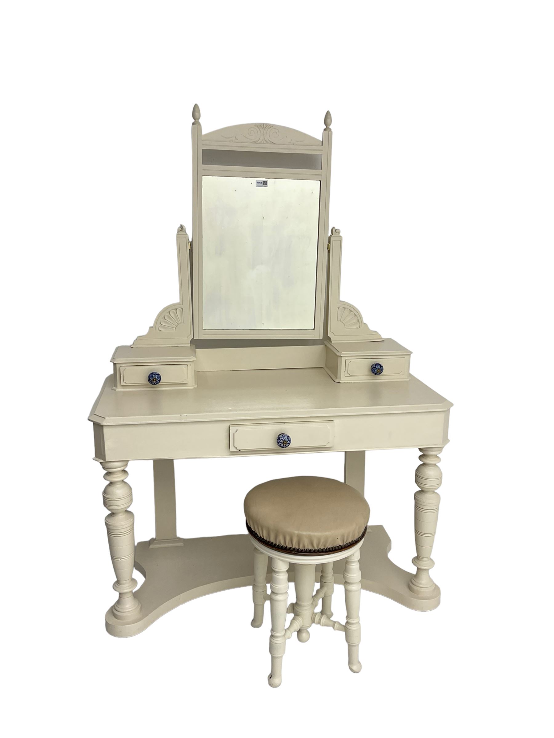 Edwardian cream painted dressing table, fitted with rectangular swing mirror over two trinket drawers with ceramic handles, rectangular top with frieze drawer, raised on turned front supports; with circular stool, leather seat over four turned supports